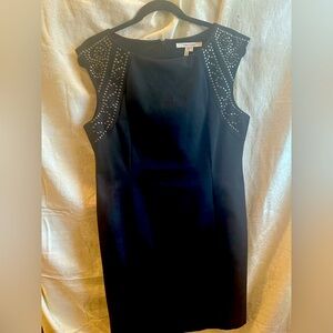 Elegant black sheath dress with beautiful studded detail. Shaped by seaming.